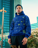 Model wearing the Cobalt Blue North Bioko Club Graffiti Hoodie in an urban outdoor setting