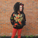Customer wearing a black North Bioko Club graphic hoodie with gold artwork and paint-effect details