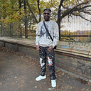 Customer styling a cream North Bioko Club graphic sweatshirt with printed trousers outdoors