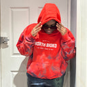 Customer wearing a red North Bioko Club hoodie with distressed details and contrasting dark paint effect