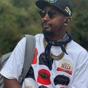 Customer styling a white North Bioko Club graphic T-shirt with red, black and cream cap artwork