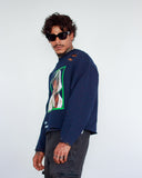 Three-quarter view of THE MUSE navy sweatshirt showing green portrait frame, raw hem and boxy silhouette